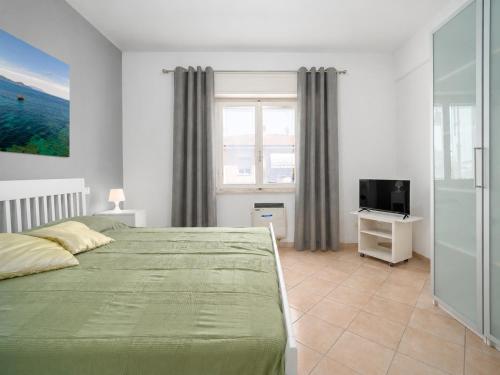 a bedroom with a green bed and a television at Excelsior - Venturina Terme in Venturina Terme