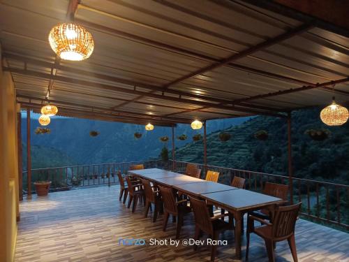 a patio with a table and chairs and lights at Dayara resort in Bhatwāri