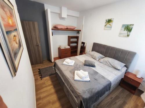 a bedroom with a bed with two towels on it at Ora Apartment in Kastel Sucurac