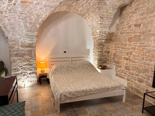 a bedroom with a bed in a stone wall at Appartamento San Giorgio in Bitonto