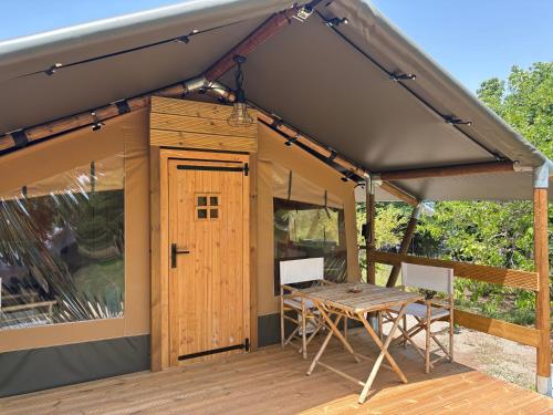 a tent with a table and chairs on a deck at Vulture Glamping in Melfi