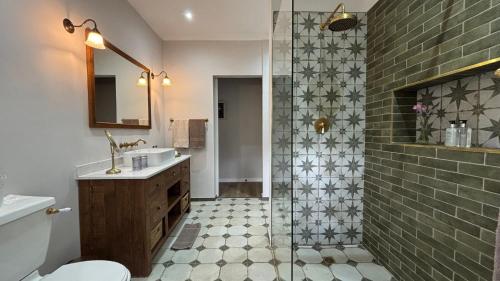 a bathroom with a shower and a toilet and a sink at L'Auberge Chanteclair in Franschhoek