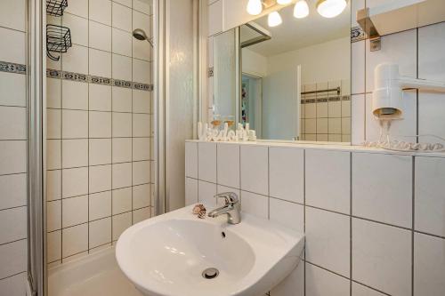 a white bathroom with a sink and a mirror at Waldsiedlung Waldhaus App 4.2 in Korswandt