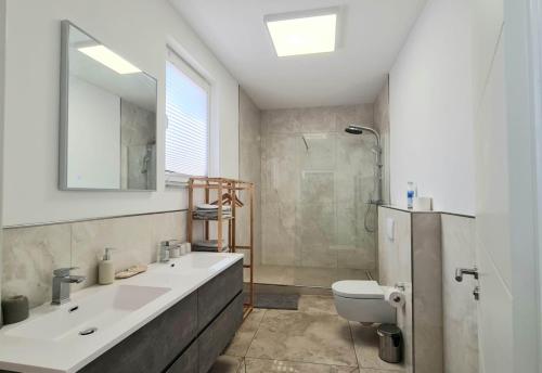 a bathroom with a sink and a toilet and a mirror at Gästehaus Ferienwohnung Wohnung #1 Jülich in Jülich