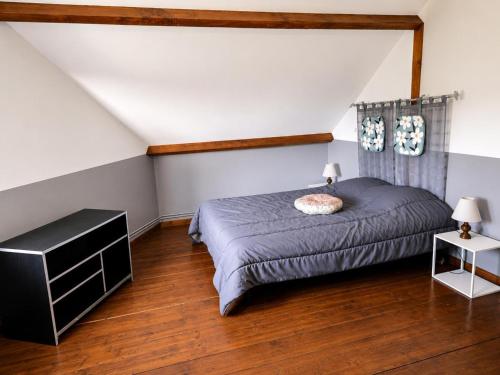 a bedroom with a bed and a wooden floor at Le p'tit bourquin in Bourg-Fidèle