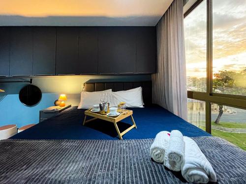 a bedroom with a bed and a table with towels on it at DVA Cabedelo by Hosppedar in Cabedelo