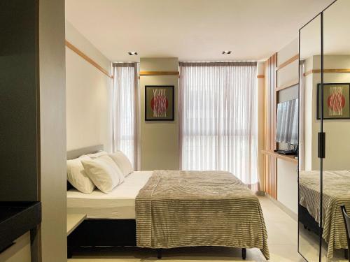 a small bedroom with a bed and a window at Hub by Hosppedar in Cabedelo