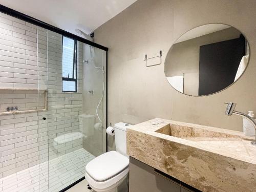 a bathroom with a sink and a toilet and a mirror at Hub by Hosppedar in Cabedelo