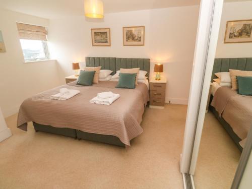 a bedroom with two beds and a mirror at Ocean Seven in Newquay