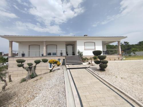 a large white house with trees in front of it at Villa Beco - Moradia de Luxo com até 6 Quartos e Piscina Privada in Monção