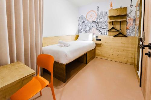 a small room with a small bed and a chair at easyHotel Alicante Centro in Alicante