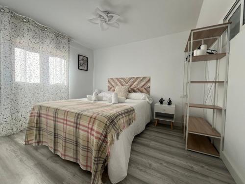 a bedroom with a bed with a plaid blanket at R2R - Casa Gatu - 307A in Cudillero