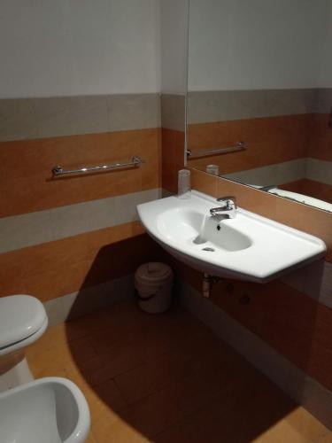 a bathroom with a sink and a toilet and a mirror at Visit San Teodoro in San Teodoro