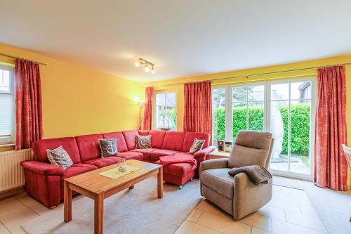 a living room with a red couch and a table at Ferienhaus Katharina in Zingst