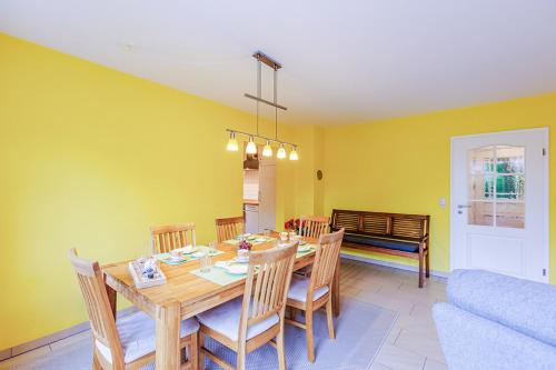 a dining room with a table and chairs and a couch at Ferienhaus Katharina in Zingst