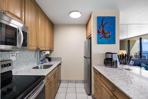 a kitchen with a sink and a refrigerator at SUGAR BEACH RESORT, #409 in Kihei