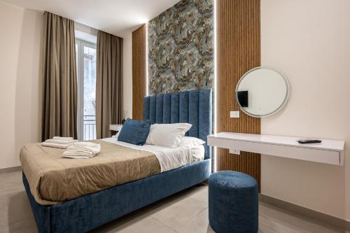 a bedroom with a bed with a blue headboard and a mirror at Guest house terra mia a Toledo in Naples