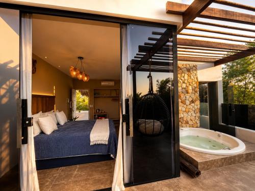 a bedroom with a bed and a tub in a room at Pura Vida Hotel in Itarema