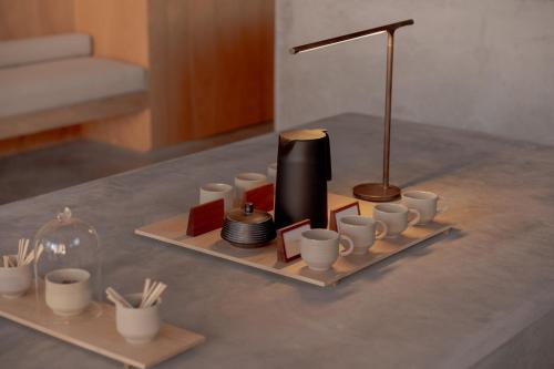 a tray with cups and a lamp on a table at Wake Medellin, a Member of Design Hotels in Medellín