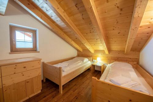 a bedroom with two beds in a wooden house at Almhäuser Filzsteinalpe Almhaus 204 in Krimml