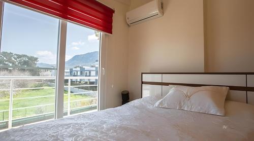 a bedroom with a bed and a large window at Villa Peri Luxury Pool Villa in Karşıyaka in Nicosia
