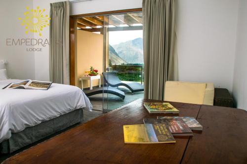 a hotel room with a bed and a table with books at Empedrada Ranch & Lodge - Hotel Asociado Casa Andina in Caral