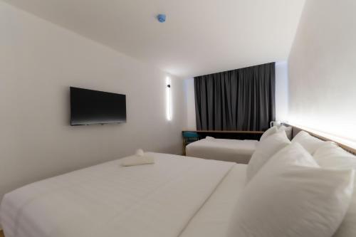 a hotel room with a bed and a flat screen tv at T Hotel SP Pekan Lama in Sungai Petani