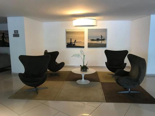 a room with chairs and a table and a painting at Landscape Beira Mar - Lindo, Luxo, Frente mar in Fortaleza