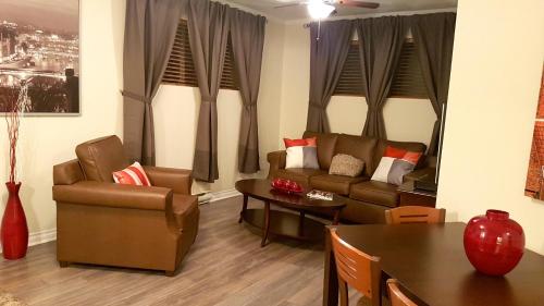 uma sala de estar com um sofá, cadeiras e uma mesa em 1-Bedroom Apartment Sweet #8 by Amazing Property Rentals em Gatineau