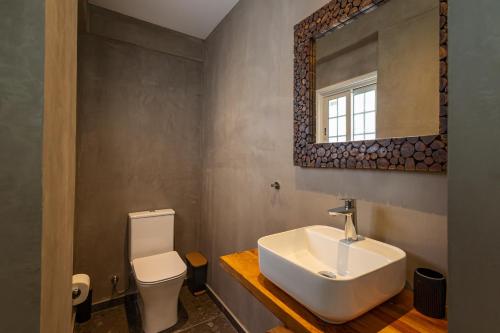 a bathroom with a sink and a toilet and a mirror at Olive Grove Apartments in Larnaca