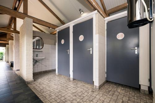 a bathroom with two blue doors and a sink at Chalet - Camping 't Dekske in Wintelre