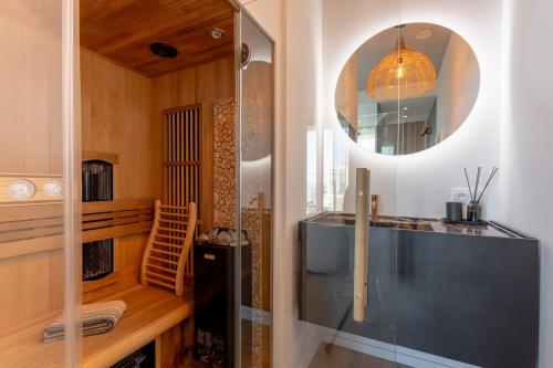 a bathroom with a glass shower and a mirror at Suite O in Ostend