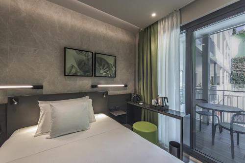 a hotel room with a bed and a balcony at Palazzo Vittoria Hotel Milano in Milan