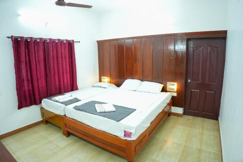a bedroom with a bed and a red curtain at Hidden Heaven Villa in Puducherry Airpoert
