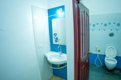 a blue bathroom with a sink and a toilet at Hidden Heaven Villa in Puducherry Airpoert