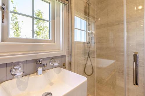 a white bathroom with a sink and a shower at 1 Bed in Beaworthy oc-93267 in Ashwater