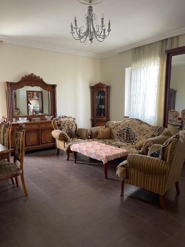 a living room with a couch and chairs and a mirror at JB Dubendi house in Baku