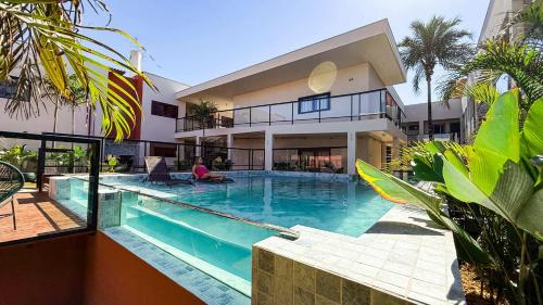 a house with a swimming pool in front of it at Blie Hotéis - Inauguração in Bonito