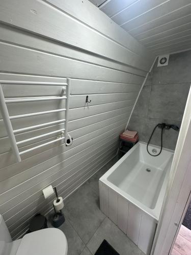 a bathroom with a white tub and a toilet at Black Pepper in Yaremche