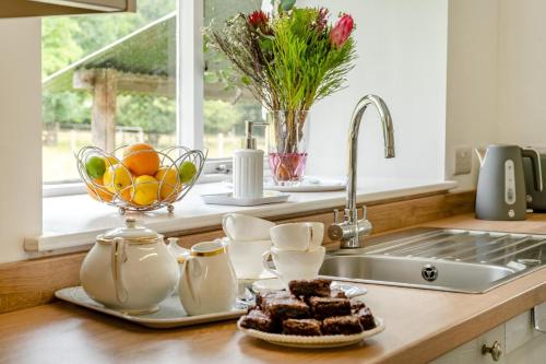 a kitchen counter with a sink and a bowl of fruit at 2 Bed in Llangynidr oc-l31914 in Llangynidr
