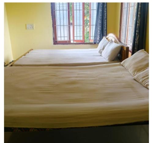a large bed in a bedroom with a window at Shree SaiRenu near maruthamalai and bharathiyar univ and on the way to Adiyogi Isha Yoga centre in Marudhamalai