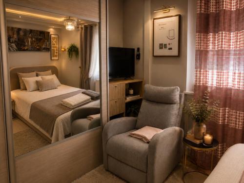 a bedroom with a bed and a chair and a mirror at Elegancia del JJM in Annemasse