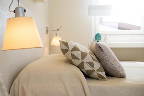 a bedroom with a bed with a lamp and pillows at MelRose Relais in Massa Lubrense