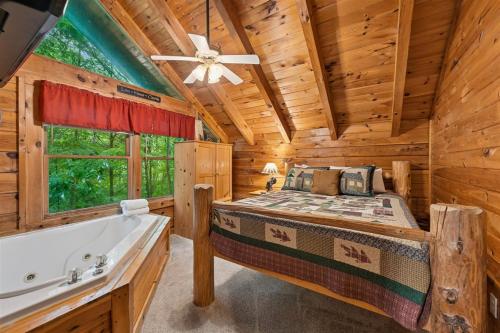 a log cabin bedroom with a bed and a bathtub at A Rustic Elegance #4 by Venture Smoky Mountains in Sevierville