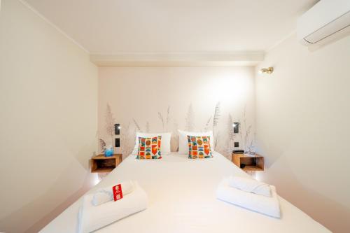 a bedroom with a large white bed with two pillows at Logis Hotel de l'Artuby in Séranon