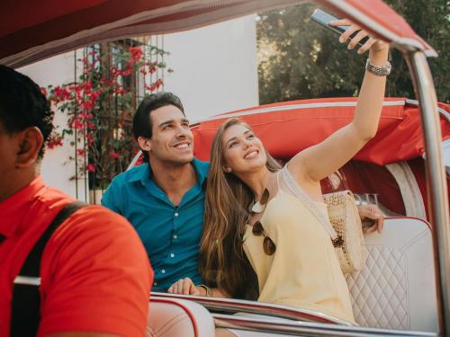 a man and a woman sitting in a car at Billini Hotel, Historic Luxury in Santo Domingo