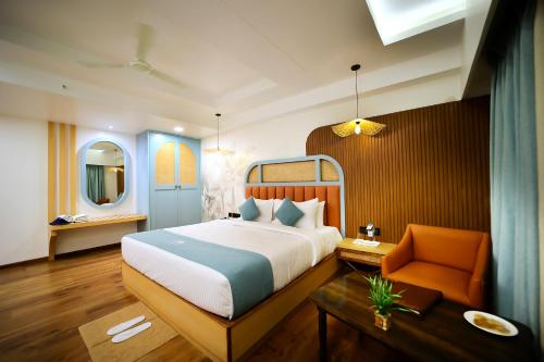 a bedroom with a bed and a chair and a mirror at Surya Garden in Tālcher