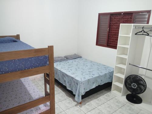 a bedroom with two bunk beds and a refrigerator at casa de temporada Império 1 in Olímpia