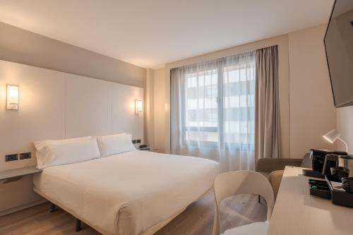 a hotel room with a white bed and a window at B&B HOTEL Castellón in Castellón de la Plana