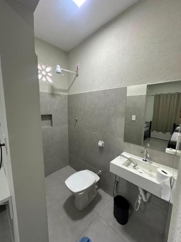 a bathroom with a toilet and a sink at Center in Uberlândia